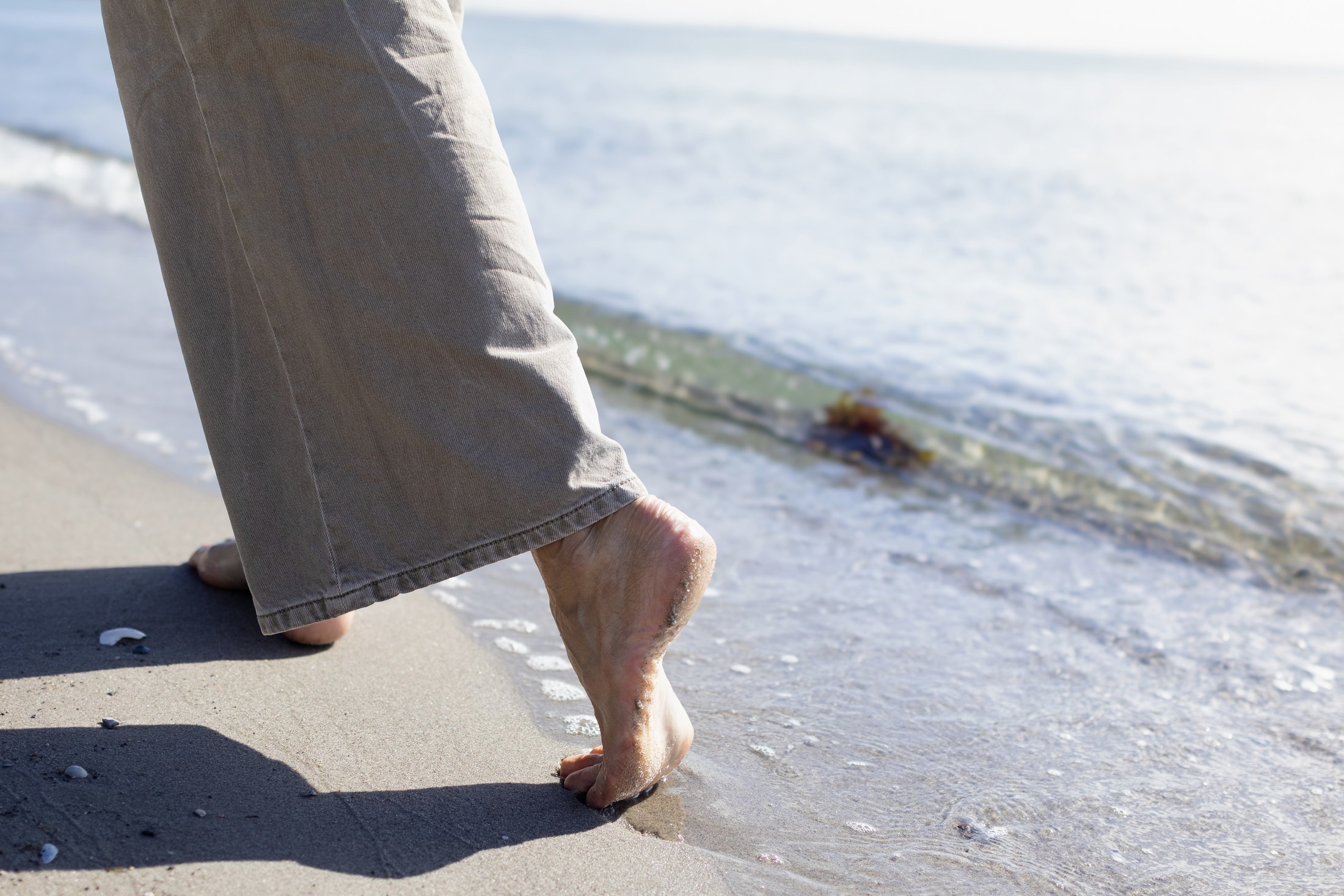 Fødder i vandkanten på stranden