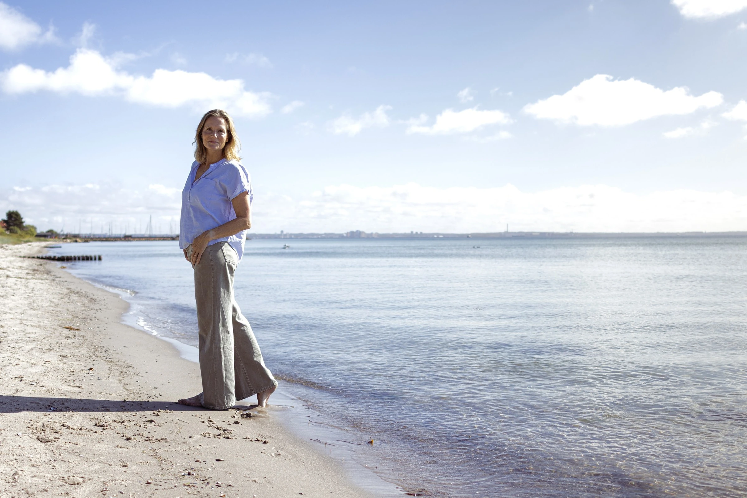 Mette Thaisen på stranden, i ro med havet i baggrunden
